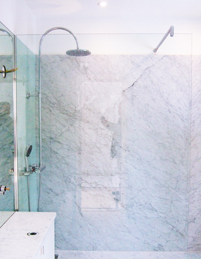 walk-in shower with glass and marble