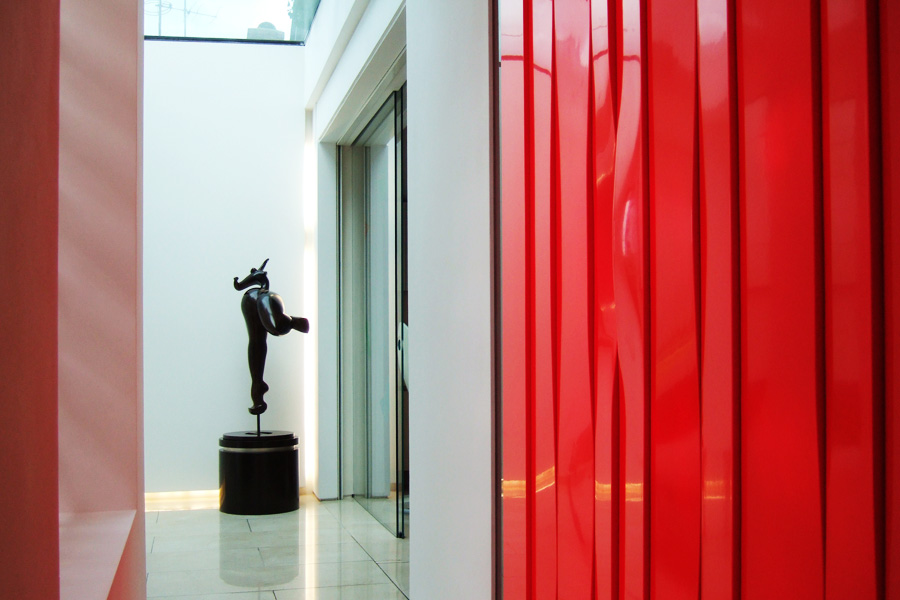 Bright entrance hall with a marble floor, red reflective curtain and a view to the sky.