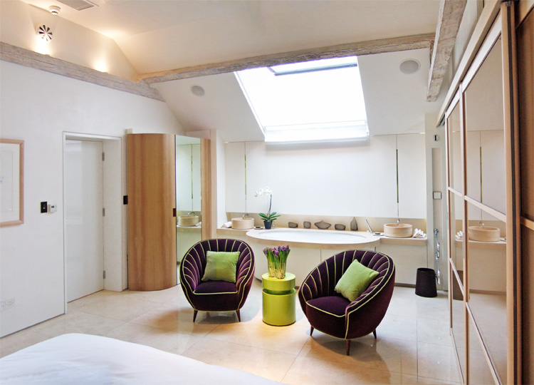 Bedroom with sunken bath to one end naturally illuminated by a rooflight directly above