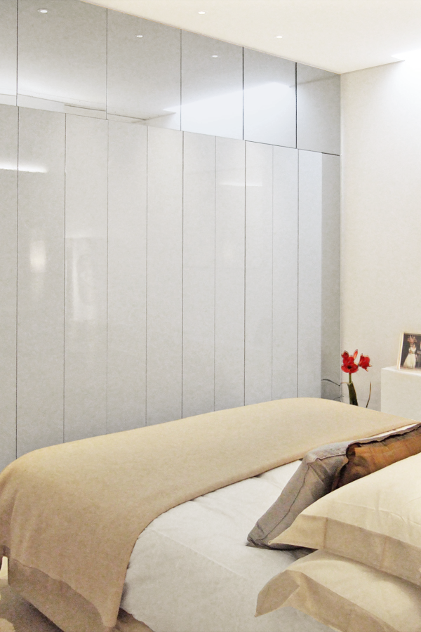 Bedroom storage with a mirror surround to appear as a screen