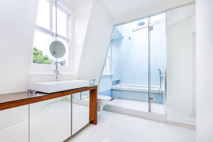 Ensuite walk-in shower with large rooflight above and basin on wooden counter