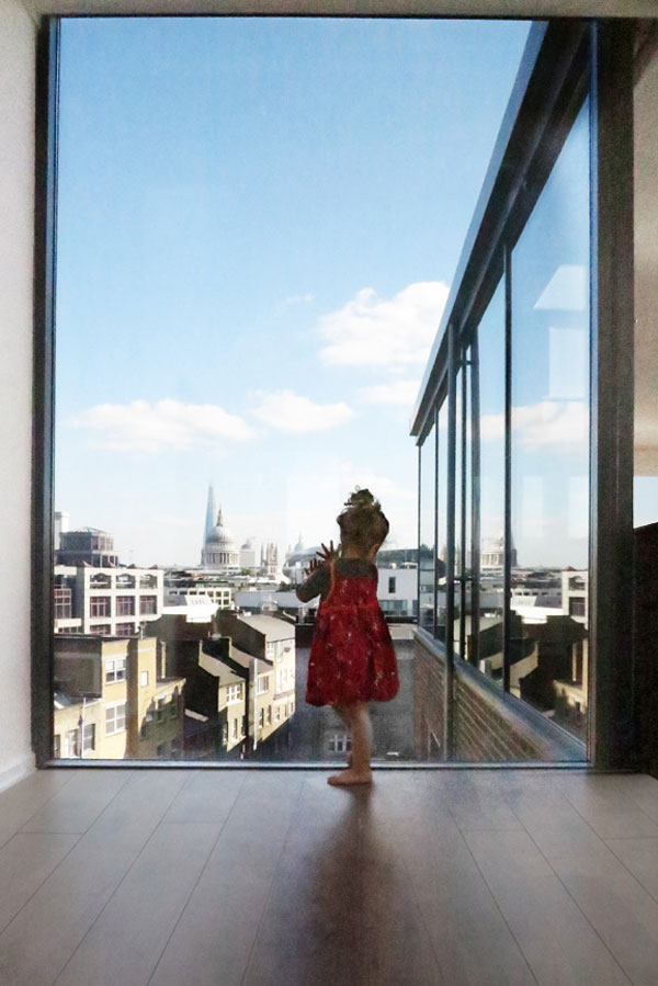 Child in window overlooking St Pauls and the London skyline
