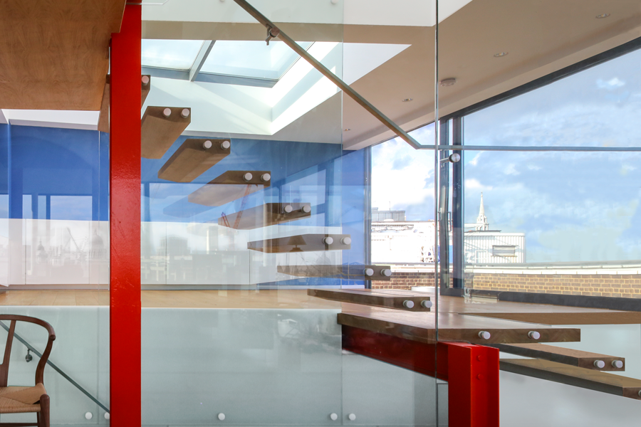 Wooden steps between glass in front of blue wall