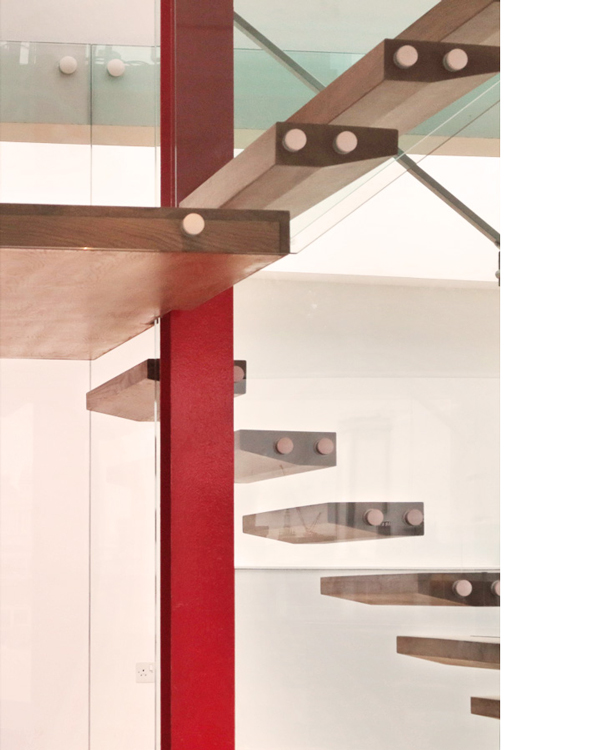 Floating timber treads wrap around red steel post