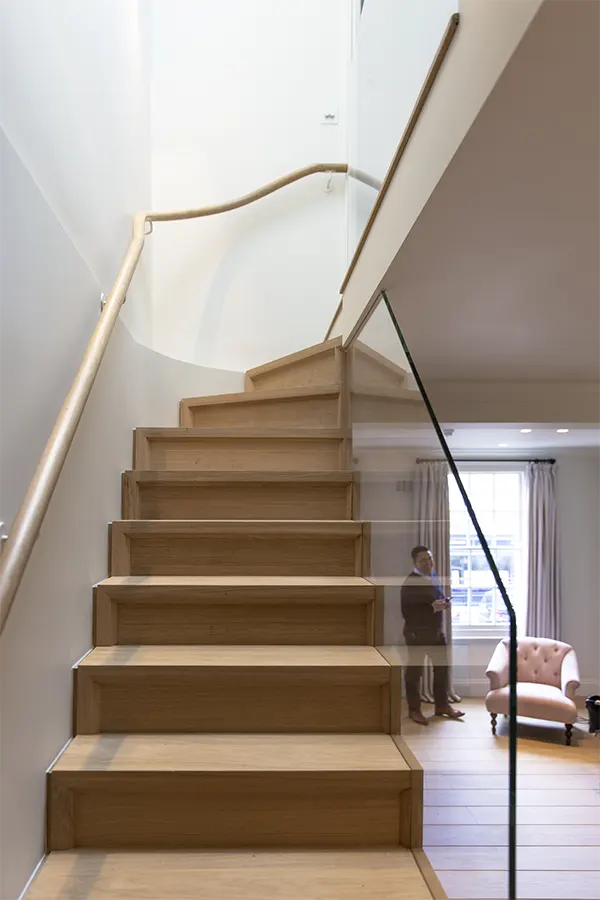 View up oak stairs with living room sash window in background