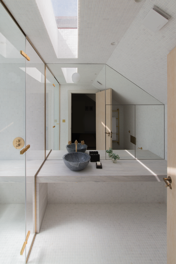 Marble counter and mosaic walls beside walk-in shower
