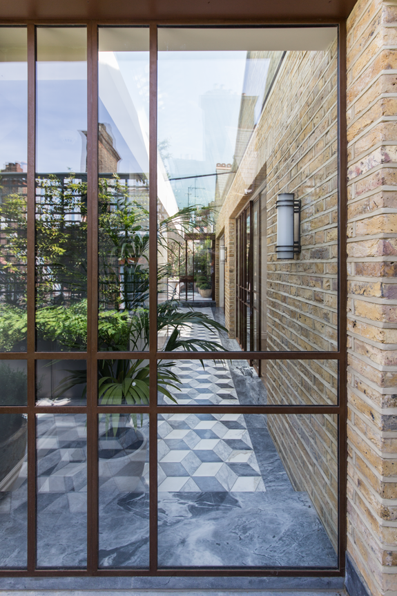Patinated steel frame doors to the roof garden with skylight behind