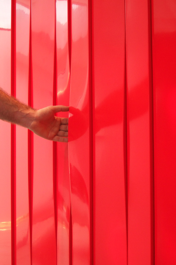 Wavy curtain detail of red reflective cupboard doors