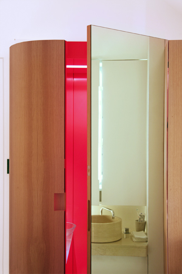 Bespoke joinery enclosure with a curved edge veiling the WC