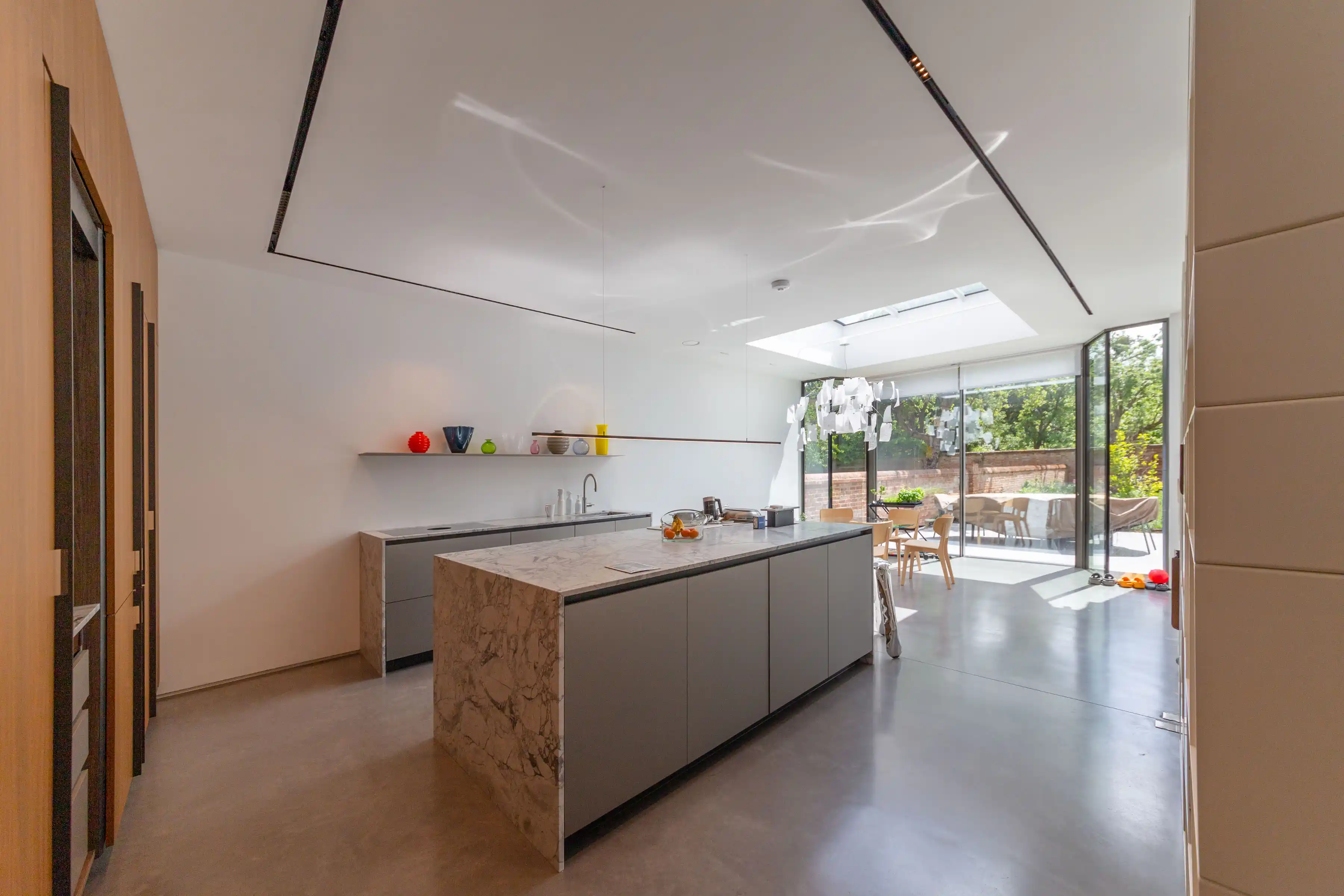 Kitchen in the new ground-floor extension at Staverton Road Oxford — marble island, grey Molteni Dada units, large rooflight, glazed sliding doors to garden terrace