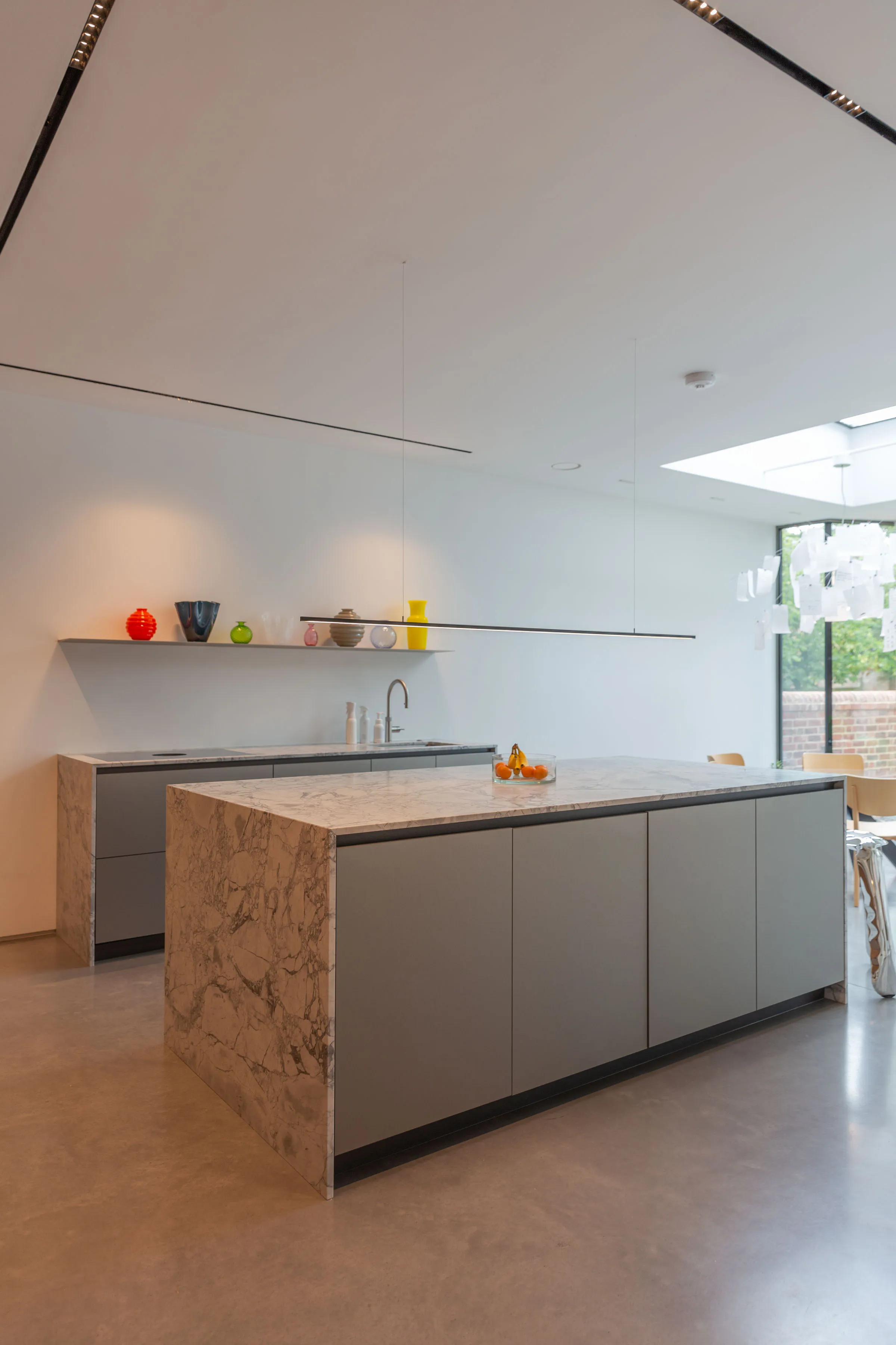 Kitchen at Staverton Road Oxford — grey Molteni Dada units with Calacatta marble island end, rooflight above, garden glazing beyond