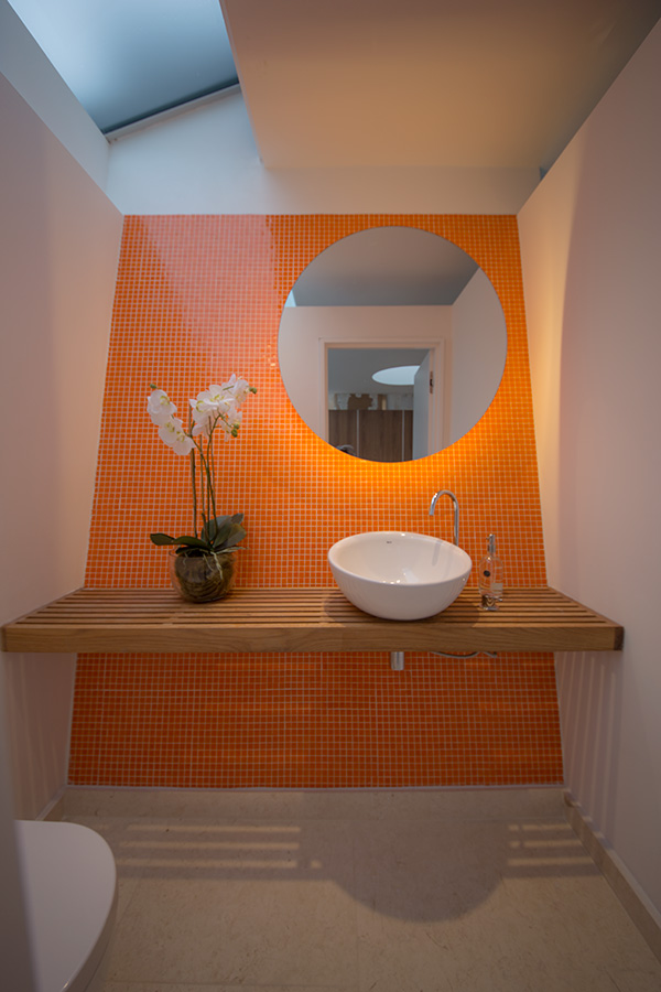 Guest cloakroom orange mosaic with oak shelf